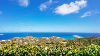 Spectacular panoramic views of St. Barths' verdant hills and the sparkling blue ocean from this luxury hillside villa.