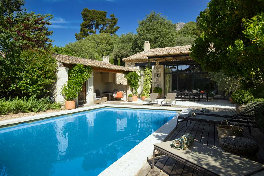 Private pool and sun loungers at Mas de Marie, a luxury stone villa in Provence with manicured gardens and elegant terraces.