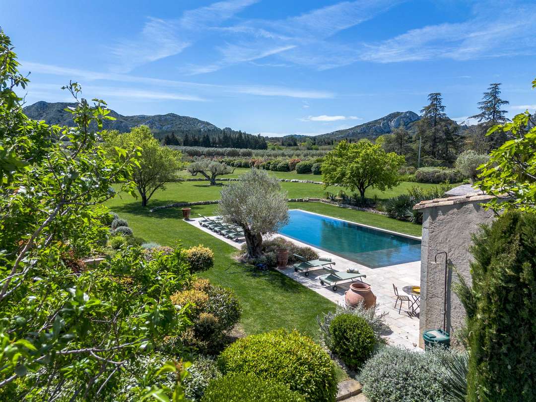 Elevated view of the private pool and manicured gardens at Mas des Rêveries, offering panoramic countryside mountain views.