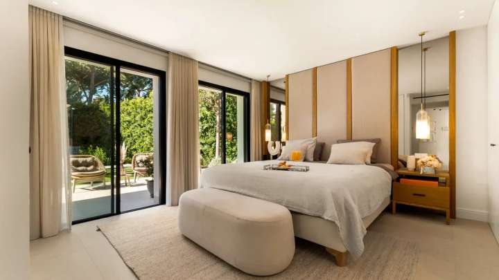 Spacious bedroom suite at Monteros Sands offering a plush bed, elegant headboard, and direct garden terrace access.