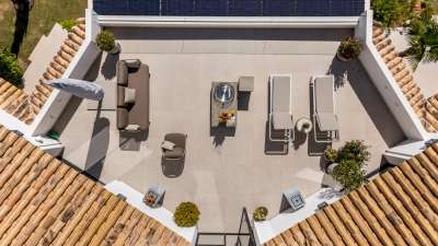 Aerial view of Monteros Sands' spacious rooftop terrace featuring elegant lounge seating, sun loungers, and a modern fire pit.