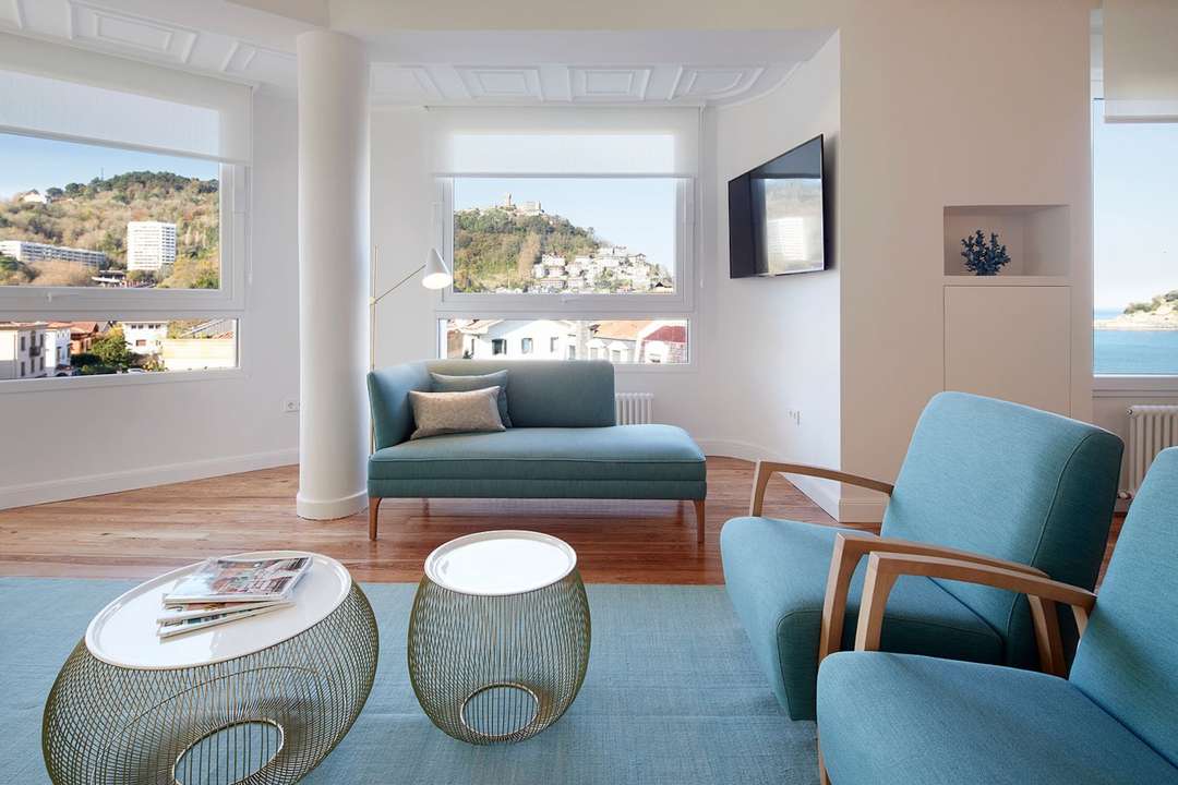 Elegant living area in Mayflower Apartment featuring contemporary seating, hardwood floors, and La Concha Bay views.