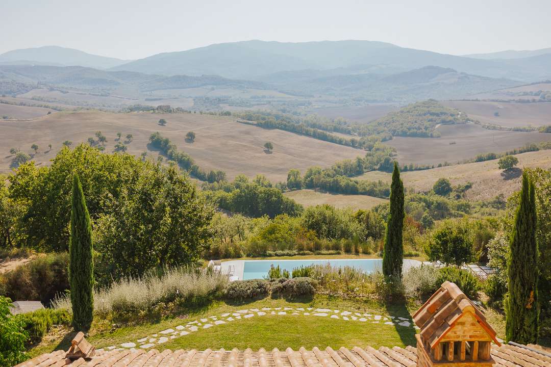 Breathtaking panoramic views of rolling Tuscan hills and vineyards from Montosca's private pool area in Siena.