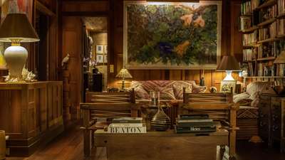 Elegant St-Barths villa living area with warm wood tones, plush sofas, curated art pieces, and an inviting atmosphere.