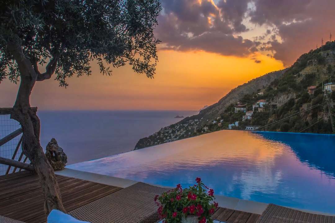 Stunning infinity pool at luxury Villa Nume offering panoramic sunset views of the Amalfi Coast and turquoise open sea.