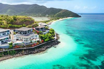 Aerial coastline view of Tamarind Hills resort villas on a bluff overlooking the soft white sands of Ffryes Beach.