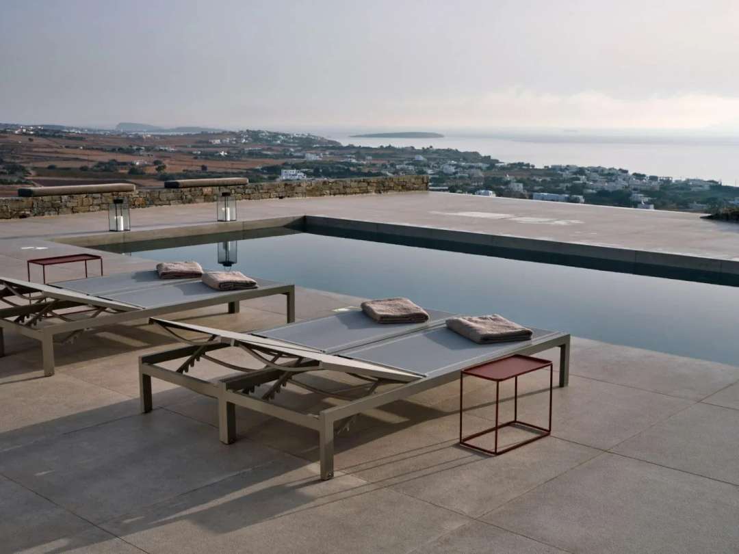 Contemporary sun loungers beside the 11-meter private pool at Villa Oriana, offering panoramic sea views over Ampelas.