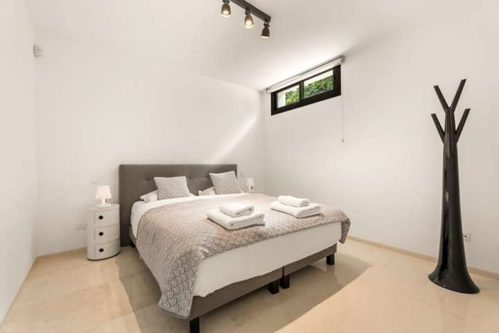 Peaceful lower-level bedroom featuring contemporary decor, a plush double bed, and elegant porcelain flooring throughout.