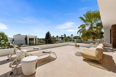 Spacious private upper terrace featuring comfortable sun loungers and peaceful views of the surrounding gardens and palm trees.