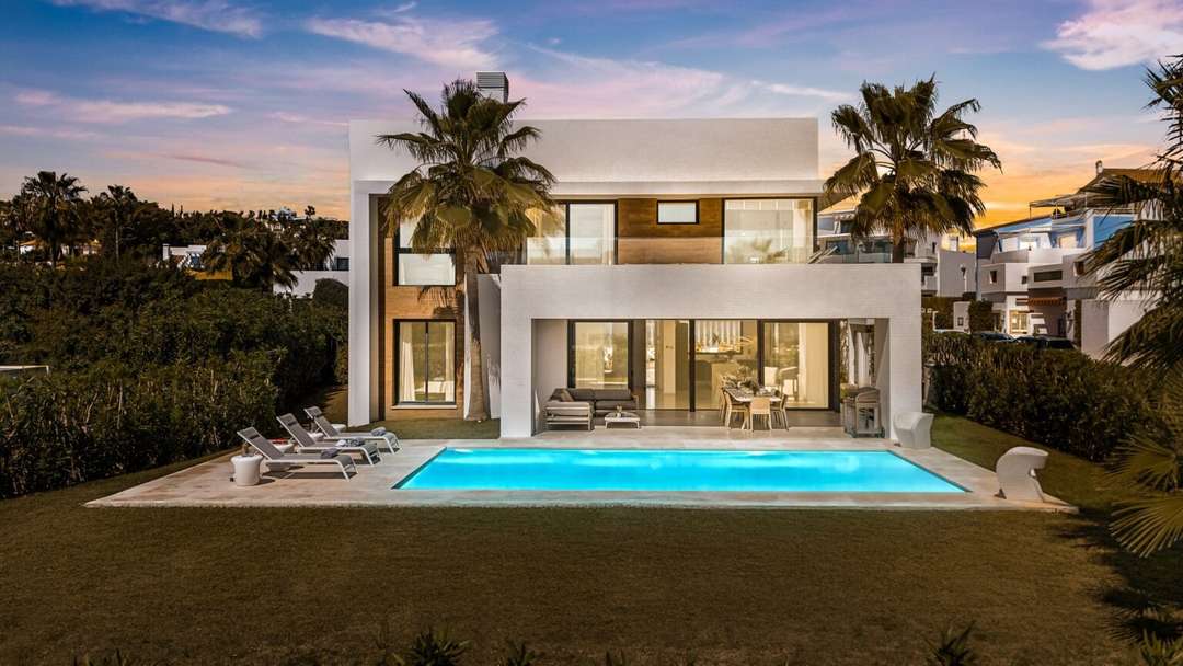 Contemporary luxury villa Paraiso Aurora at sunset, featuring a private pool, sun loungers, and elegant outdoor living spaces.