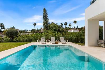 Pristine private swimming pool surrounded by manicured lawns and lush landscaped gardens at this peaceful luxury villa retreat.