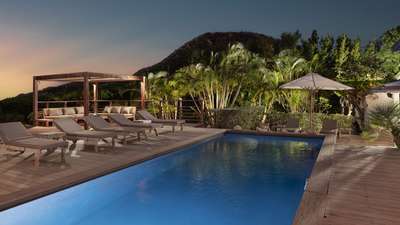 Absolute tranquility at dusk by the illuminated private pool and elegant teak terrace at the luxurious Villa Pastels.