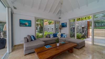 Expansive open-plan living area at Villa Reef Point, perfectly framing panoramic ocean vistas and a verdant rear courtyard.