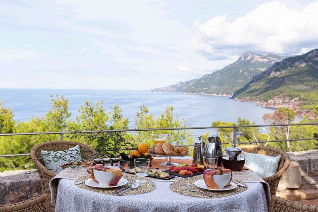 Enjoy a continental breakfast on the private terrace of Villa Sa Punta de S'Aguila with panoramic sea and mountain views.