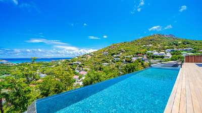 Magnificent heated infinity pool along a beautiful wooden deck, offering sweeping views of St-Jean Bay and the ocean.