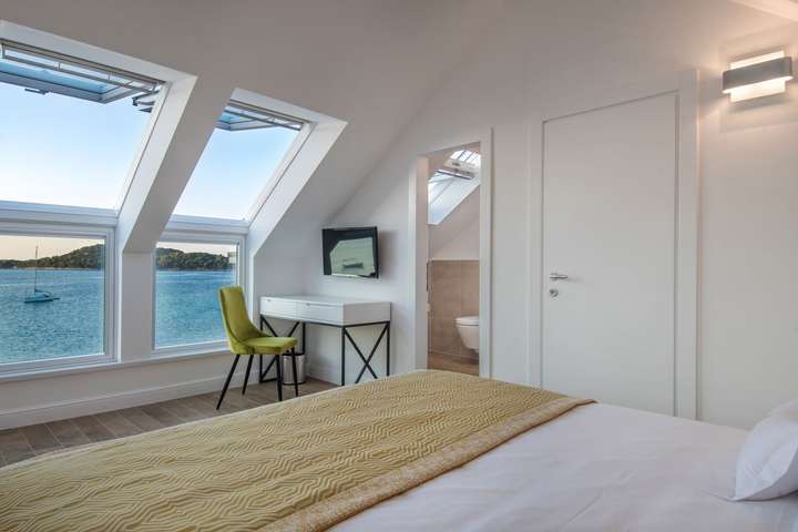 Luxury king bedroom at Seaside Bliss Korcula offering panoramic Adriatic Sea views, modern desk, and en-suite access.