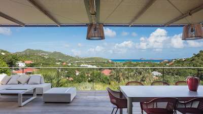 Expansive terrace at Villa Senna featuring al fresco dining, plush seating, and breathtaking panoramic Caribbean Sea views.