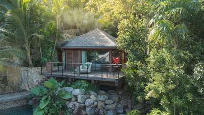 Secluded wooden bungalow bedroom nestled in verdant tropical gardens at this exquisite St-Barths luxury villa rental.