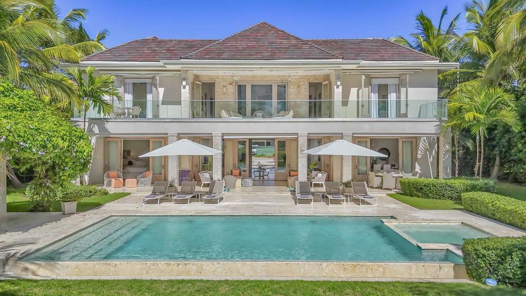 Elegant Villa Spero exterior featuring a pristine private pool, marble terrace, and chic sun loungers in lush Punta Cana.