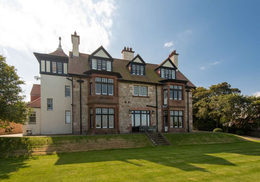 Elegant stone exterior of Bonny View villa in North Berwick, featuring a manicured lawn and classic architectural details.