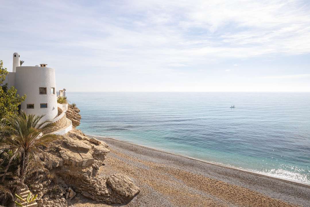 Luxury waterfront villa Stone Whisper on a rocky cliff, offering uninterrupted Mediterranean Sea views in Villajoyosa.