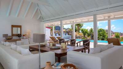 Open-concept lounge at Villa Supersky offering majestic hill and ocean views, white sofas, and a seamless terrace flow.