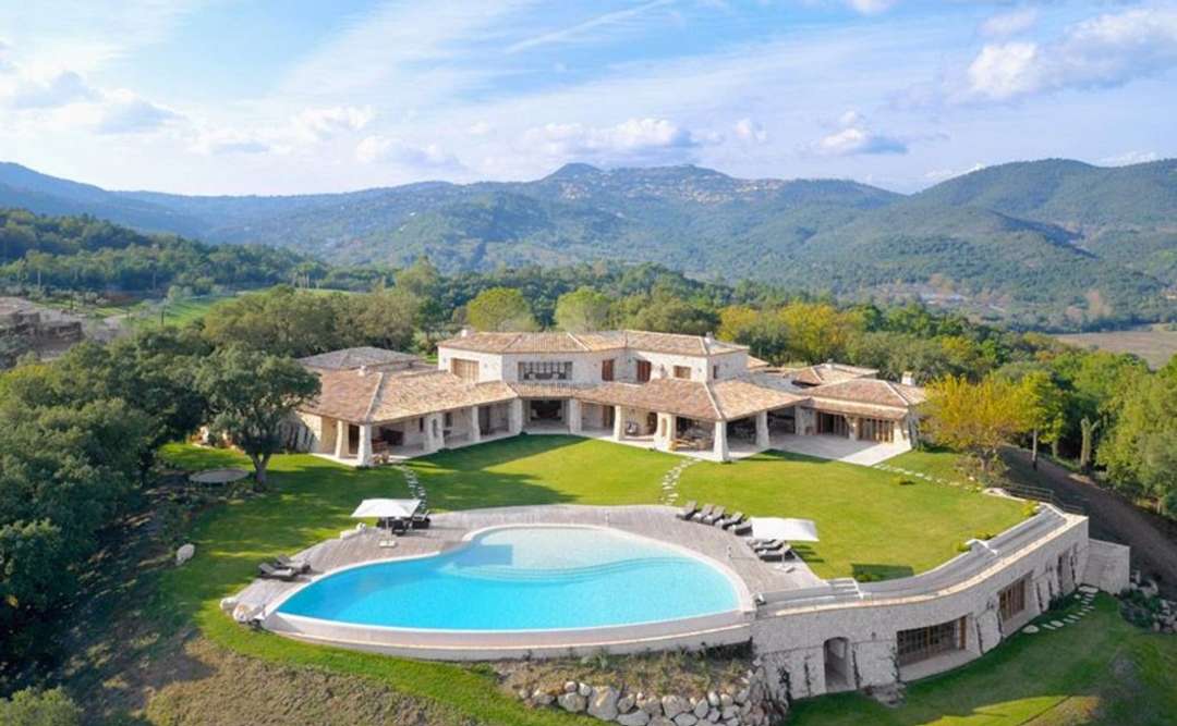 Aerial view of The King's View in Cannes, featuring a majestic stone villa, infinity pool, and panoramic mountain vistas.