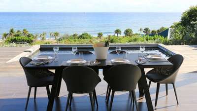 Luxurious outdoor dining setup at Villa Ti Chato with champagne, overlooking the private pool and spectacular ocean vista.
