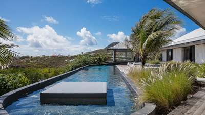 Unique heated granite pool with a floating daybed and an ajoupa for private massages at Villa Valentina, St. Barth.