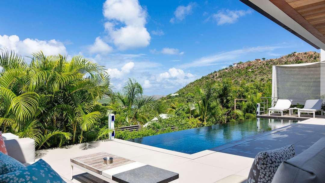 Private heated pool overlooking lush tropical hillsides from the elegant terrace at Ventura Estate, St-Barths.