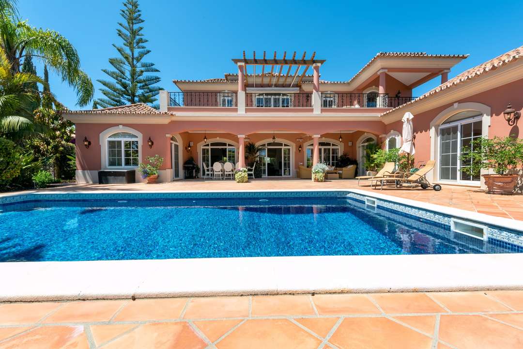 Magnificent luxury villa facade in Quinta do Lago with a large private pool, covered terrace, and alfresco dining spaces.