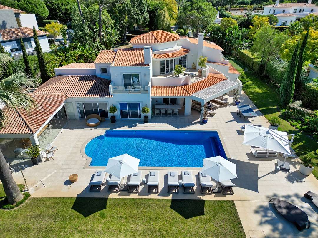 Aerial view of Villa Monte's stunning outdoor space, showcasing the large private pool, sun terrace, and lush gardens.