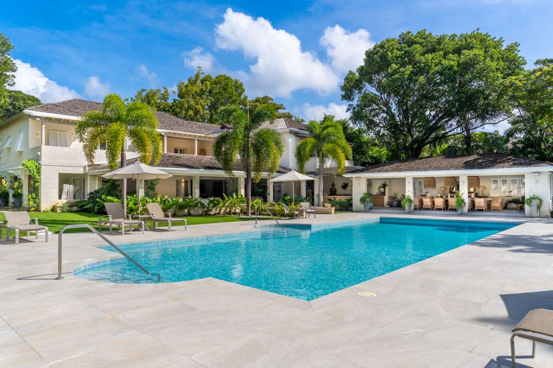 Elegant Villa Aama exterior featuring a spacious private pool, sun loungers, and covered terrace amidst manicured gardens.