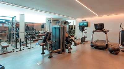 Professional-grade private gym at Villa Cavado equipped with a treadmill, cable machine, and premium fitness equipment.