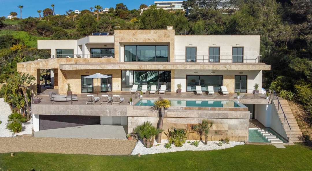 Striking contemporary villa in Sotogrande with stone facade, infinity pool, and sweeping views of the Mediterranean Sea.