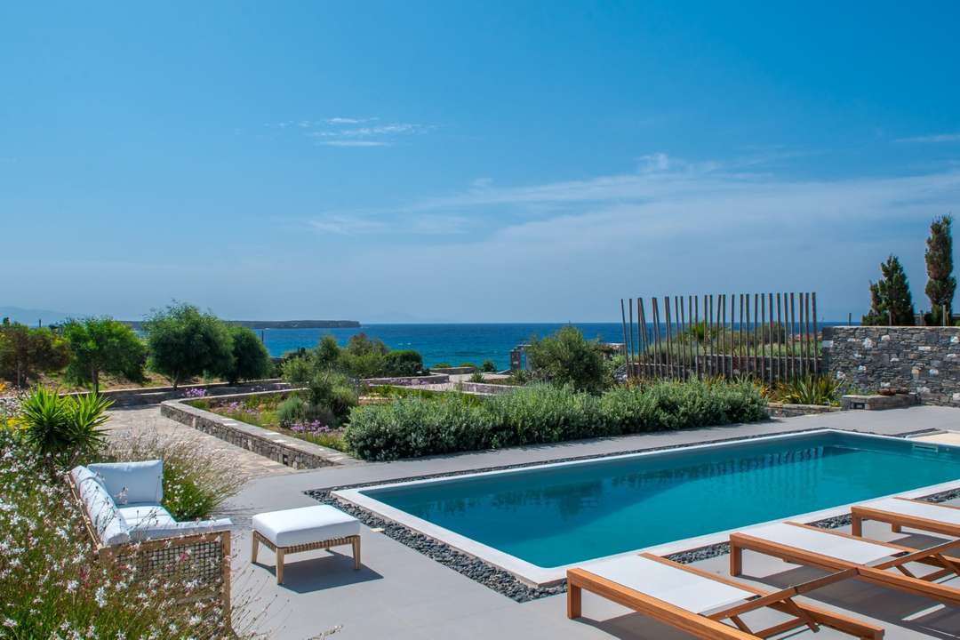 Sparkling private pool and terrace at Villa Helios, featuring elegant loungers and panoramic sea views.