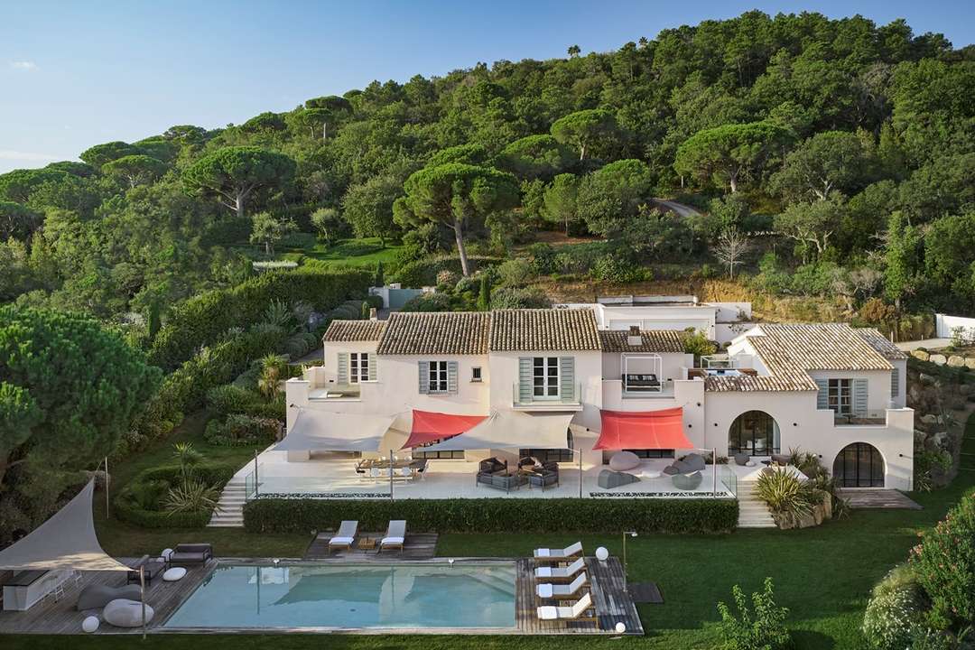 Aerial view of Villa Mariella featuring a large heated pool, manicured gardens, and elegant architecture near Saint-Tropez.