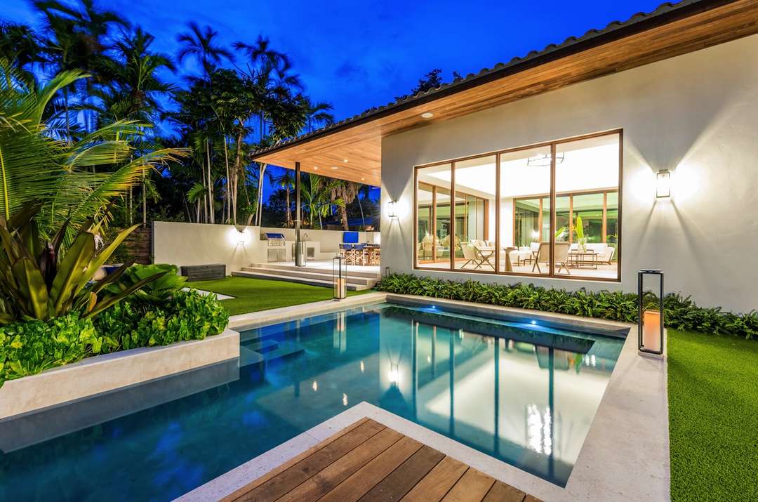 Floodlit private pool and manicured garden at Villa Marya, showcasing the illuminated open-concept living area.