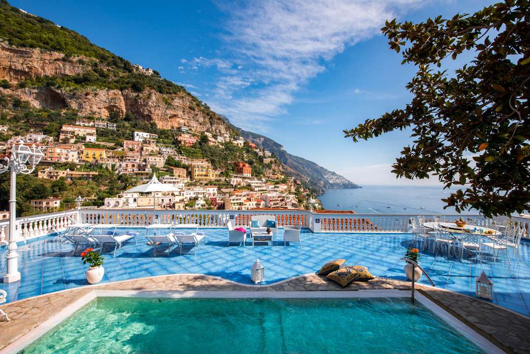 Expansive terrace with blue Vietri ceramic floors, private pool, and panoramic views of Positano and the Amalfi Coast.