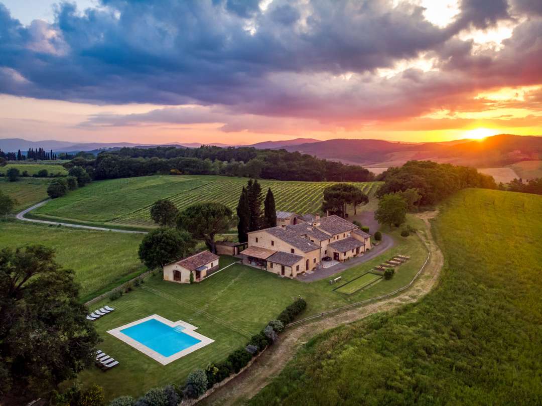 Aerial view of luxury Villa Morgana at sunset, featuring a private pool, expansive gardens, and sweeping countryside views.