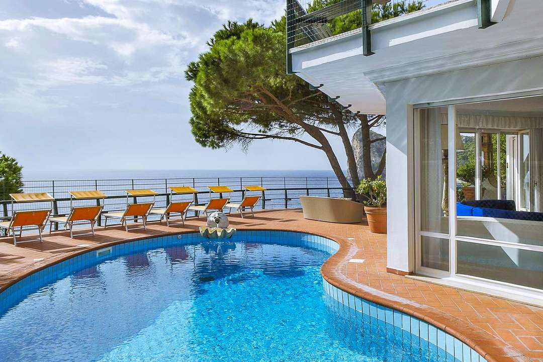 Freeform salt water pool on a terracotta terrace offering panoramic sea views at luxury Villa Nerano on the Amalfi Coast.