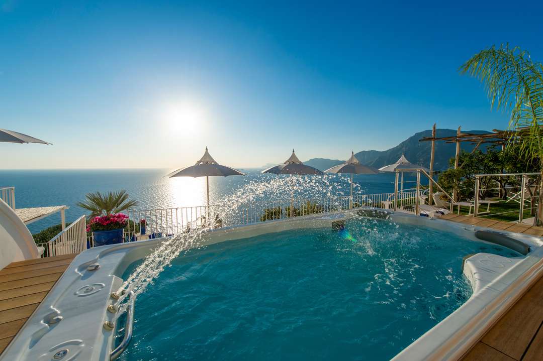 Heated outdoor jacuzzi on a wooden deck at Villa Nuea, offering breathtaking Mediterranean Sea views for luxury travelers.