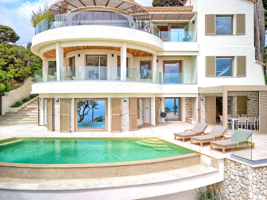 Villa Rosalie's stunning exterior features a private infinity pool, curved sea-view terraces, and elegant stone architecture.