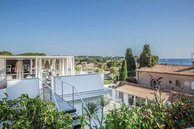 Rooftop terrace at Villa Sandara in Cap d'Antibes featuring a white pergola, al fresco dining, and panoramic sea views.