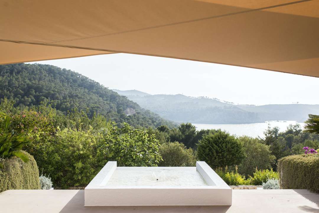 Ornamental fountain on a shaded terrace at Villa Santy, offering breathtaking sea and nature views in Ibiza.