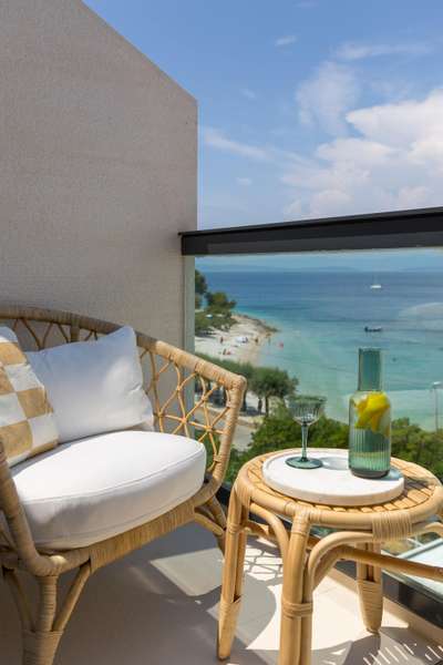Enjoy beachfront luxury on this private balcony, featuring elegant seating and direct views of the Dalmatian coast.