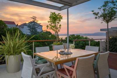 Elegant covered outdoor dining terrace at sunset, offering breathtaking Adriatic Sea views for refined alfresco entertaining.