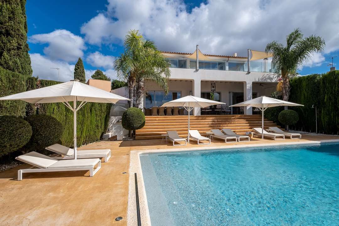 Elegant saltwater swimming pool and sun terrace at Villa Tiera, a luxury modern retreat in Palma with lush Mediterranean gardens.