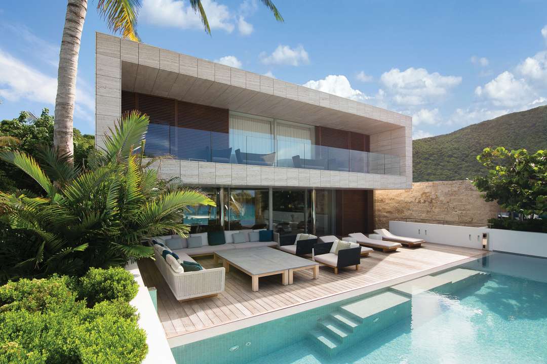 Elegant travertine exterior of Villa Wake Up featuring a heated pool, spacious terrace, and plush outdoor lounge seating.