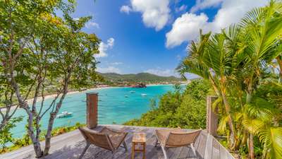 Bask in the Caribbean sun on the expansive wooden terrace at Villa Xanadu, offering panoramic views of the sparkling St Jean bay.
